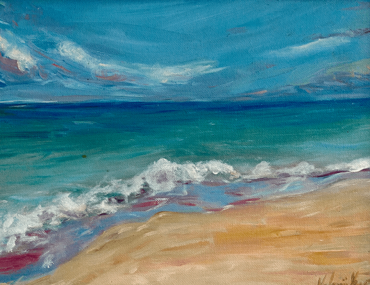 Framed painting of a beach scene with blue sky and ocean on a beige wall.